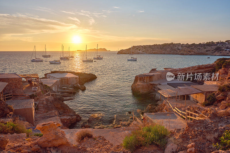 Es Calonet, Cala Tarida，风景优美的海湾与一小群渔民的小屋在日落，伊比沙岛，西班牙